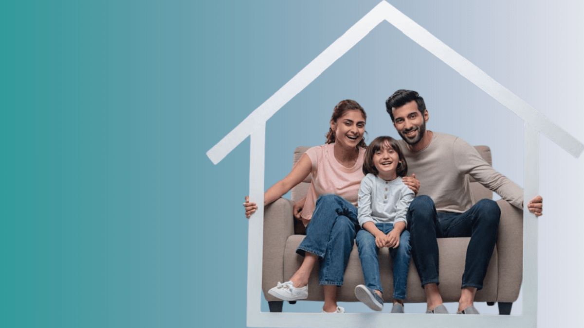 A young family sitting together under the outline of a house
